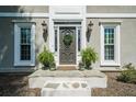 Close-up of the front door with decorative wreath, sidelights, potted plants, and stone steps at 435 Chantenay Pl, Alpharetta, GA 30022