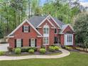 Charming brick home with lush green lawn, trimmed bushes, and a welcoming walkway to the front entrance at 250 Chason Wood Way, Roswell, GA 30076