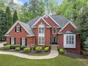 Classic brick home featuring a well-kept lawn, neatly arranged shrubbery, and a cozy, inviting front entrance at 250 Chason Wood Way, Roswell, GA 30076