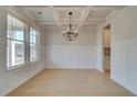 Dining room with elegant coffered ceiling, wainscoting and large window for natural light at 520 Dulles Dr, Mcdonough, GA 30253