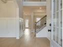 Bright foyer with hardwood floors, a staircase with rod iron spindles, and wainscoting at 520 Dulles Dr, Mcdonough, GA 30253
