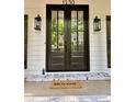 Elegant double front doors with glass panels, accented by stylish lanterns and a 'welcome' mat at 1230 Sunderland Ne Ct, Brookhaven, GA 30319