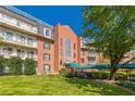 Multi-story brick building with balconies, a green awning, and a well-manicured lawn at 28106 Plantation Ne Dr, Atlanta, GA 30324