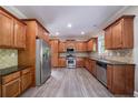 Spacious kitchen featuring wooden cabinetry, stainless steel appliances, and dark countertops at 3460 Village Park Sw Ln, Atlanta, GA 30331