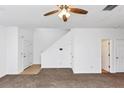 Spacious living room featuring new carpet, a ceiling fan and entry to stairs at 2530 Marlin Dr, Mcdonough, GA 30253