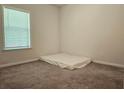Clean, carpeted bedroom with natural light from a window and neutral color at 261 Mahone Dr, Lilburn, GA 30047