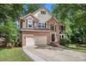 Classic two-story home boasts brick and siding exterior, a two-car garage, and mature landscaping at 300 Wesfork Nw Way, Suwanee, GA 30024