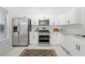 Modern kitchen with stainless steel appliances, white cabinetry, and marble countertops at 1135 Kilmington Ct, Alpharetta, GA 30009