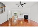 Spacious living room with hardwood floors, fireplace, and a modern ceiling fan at 1135 Kilmington Ct, Alpharetta, GA 30009