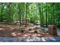 Scenic view of wooded property with a charming home and mature trees at 1348 Timberland Se Dr, Marietta, GA 30067