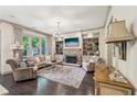 Bright living room with a stone fireplace, custom built-ins, hardwood floors, and elegant decor at 306 Nottaway Ln, Alpharetta, GA 30009