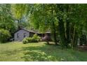 House with green lawn, mature trees, and a covered front porch, creating a peaceful and inviting exterior at 1429 Smithson Dr, Lithonia, GA 30058