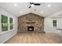 Inviting living room featuring a stone fireplace, hardwood floors, recessed lighting, and large windows at 3952 Leisure Se Ct, Conyers, GA 30013