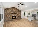 Open-concept living room with a stone fireplace, and seamlessly connects to a modern kitchen with a central island at 3952 Leisure Se Ct, Conyers, GA 30013
