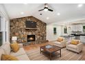 Inviting living room showcasing a stone fireplace, recessed lighting, ceiling fan, and seamlessly connected kitchen at 3952 Leisure Se Ct, Conyers, GA 30013