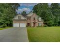 Beautiful two-story brick home with a well-manicured lawn, mature trees, and a convenient two-car garage at 4942 Brown Leaf Dr, Powder Springs, GA 30127
