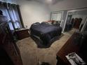 Bedroom featuring a king-sized bed, a closet with mirrored doors, and carpeted flooring at 135 Governors Rdg, Auburn, GA 30011