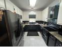 Modern kitchen featuring sleek black appliances, white cabinets, and stylish countertops at 135 Governors Rdg, Auburn, GA 30011