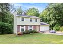 Two-story home featuring an attached two-car garage, well-maintained lawn, and lush surrounding trees at 2722 Springside Ct, Douglasville, GA 30135