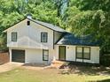 Charming two-story home featuring a black roof, white siding, and a neatly maintained front yard at 3988 Chimney Ridge Dr, Ellenwood, GA 30294