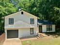 Charming two-story home featuring a black roof, white siding, and a neatly maintained front yard at 3988 Chimney Ridge Dr, Ellenwood, GA 30294