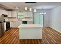 Bright kitchen featuring white cabinets, quartz countertops, an island, and modern stainless steel appliances at 3988 Chimney Ridge Dr, Ellenwood, GA 30294