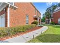 Exterior side view of a brick home featuring a walkway with garden lights and landscaping at 988 Treymont Way, Lawrenceville, GA 30045