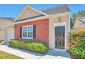 Inviting home exterior with a brick facade, a manicured hedge, and an elegant entrance door at 1015 Lakeside Cir, Covington, GA 30016