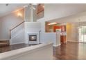 Bright living room featuring a fireplace, hardwood floors, and an open concept to the kitchen at 1015 Lakeside Cir, Covington, GA 30016