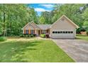 Charming single-story home featuring a well-maintained lawn and a two-car garage at 3663 Homewood Trl, Powder Springs, GA 30127