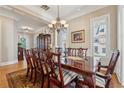 Formal dining room with a large wooden table, chandelier lighting, and decorative accents at 11715 Dancliff Trce, Alpharetta, GA 30009