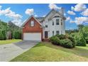 Charming two-story home features brick and vinyl siding with an attached two-car garage at 1405 Bramlett Forest Trl, Lawrenceville, GA 30045