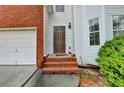 Close-up of front entry with brick steps leading to brown front door, with sidelight window detail at 1405 Bramlett Forest Trl, Lawrenceville, GA 30045