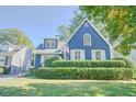 Attractive blue home featuring white trim, shutters, manicured bushes and a green lawn at 2195 Edison Ne Ave, Atlanta, GA 30305