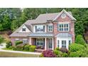 Beautiful two-story brick home featuring a manicured lawn and attractive landscaping at 621 Oakbourne Way, Woodstock, GA 30188