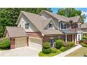 Side view of a stunning brick home featuring attached garage, well-manicured landscaping, and charming architectural details at 621 Oakbourne Way, Woodstock, GA 30188