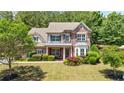 Beautiful two-story brick home with manicured lawn and mature trees at 621 Oakbourne Way, Woodstock, GA 30188