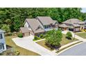 Rear exterior featuring a three car garage, extensive driveway and lush landscaping at 621 Oakbourne Way, Woodstock, GA 30188