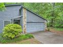Two-car garage with gray wood facade and stone accents and concrete driveway at 1515 Barrier Rd, Marietta, GA 30066