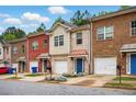 Exterior of a row of townhomes featuring brick facades, garages, and well-maintained landscaping at 5019 Lower Elm St, Atlanta, GA 30349