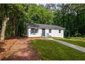 Charming one-story home boasting a white exterior, gray roof, and beautiful green lawn at 2889 Macon Sw Dr, Atlanta, GA 30354