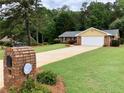 Well-maintained home with a long driveway, lush green lawn, and brick mailbox at 1818 Brandy Woods Se Dr, Conyers, GA 30013