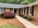 Inviting entryway with a decorative tree, brick facade, and well-kept landscaping at 1818 Brandy Woods Se Dr, Conyers, GA 30013