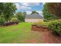 Spacious side yard featuring lush grass and a brick retaining wall, perfect for gardening at 65 Wisteria Blvd, Covington, GA 30016