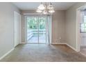 Dining area featuring a sliding door to the back porch, carpet, neutral paint and modern light fixture at 6595 Oakwood Dr, Douglasville, GA 30135