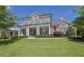 Beautiful two-story brick home with lush landscaping and a charming covered front porch with elegant columns at 3264 Andante Ne Dr, Marietta, GA 30062