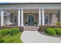 Inviting front porch with white columns, stylish hanging lights, and a cozy porch swing for relaxing outdoors at 3264 Andante Ne Dr, Marietta, GA 30062