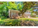 Front exterior view of a split-level house with a brick porch and an attached garage at 802 San Miguel Dr, Stone Mountain, GA 30083