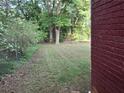 Spacious backyard featuring manicured lawn and privacy from mature trees at 947 Meadow Rock Dr, Stone Mountain, GA 30083