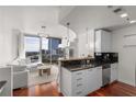 Open living room/kitchen with white cabinets, stainless appliances, and skyline views at 3324 Peachtree Ne Rd # 1304, Atlanta, GA 30326